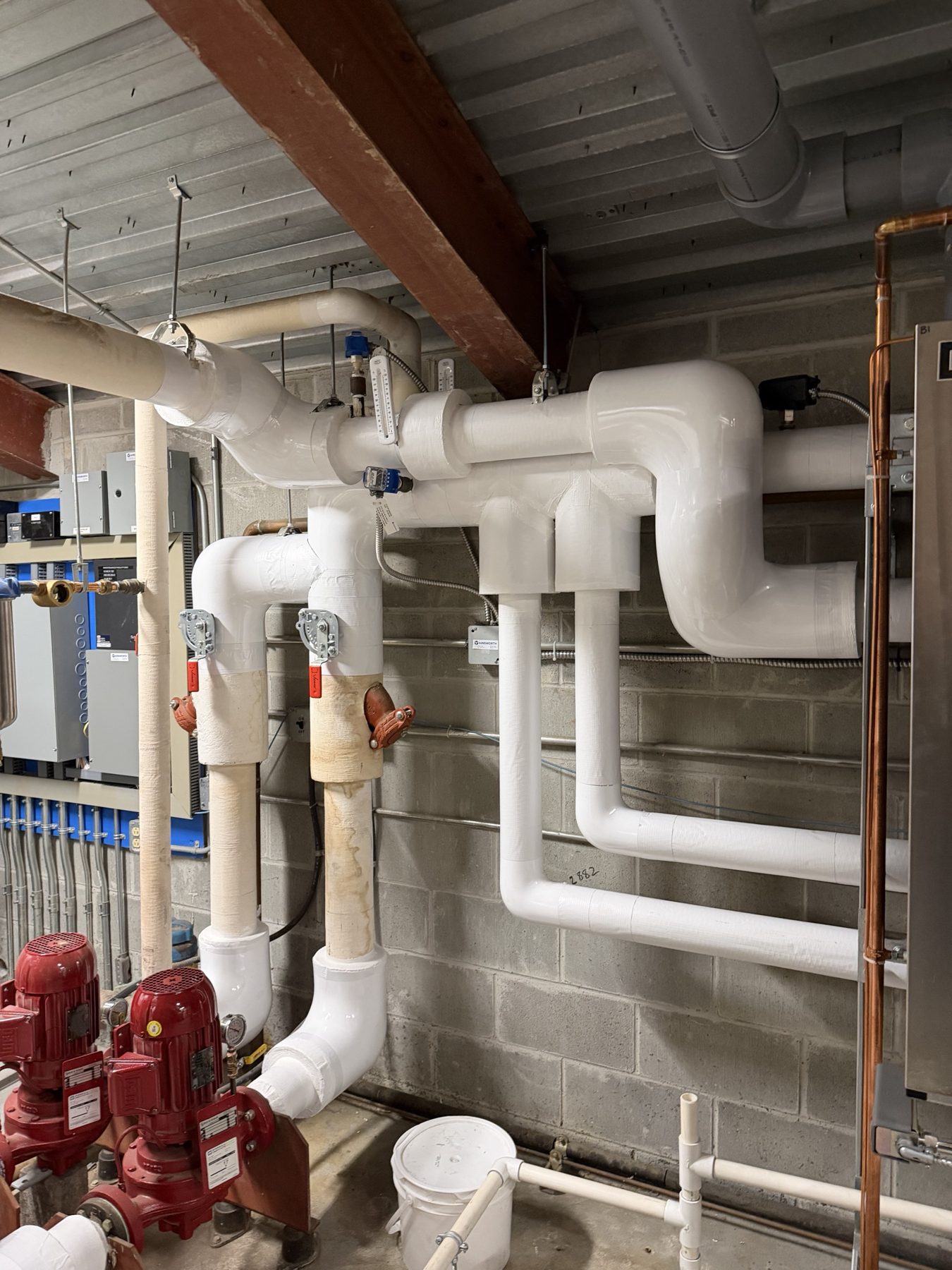 Insulated hydronic piping in a mechanical room, PVC jacketed